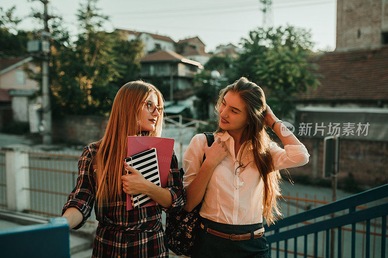 快乐的女学生背着书和背包去上学