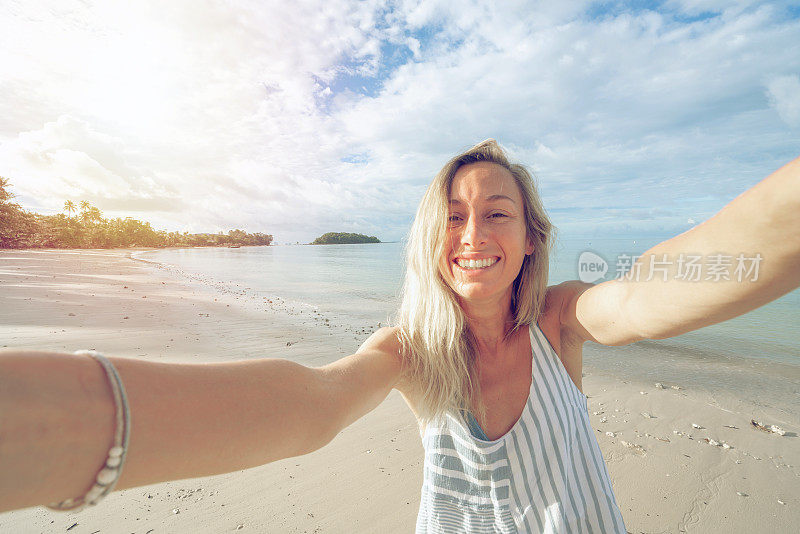 一名年轻女子在泰国海滩上自拍。人们旅行豪华度假乐趣和酷的态度概念