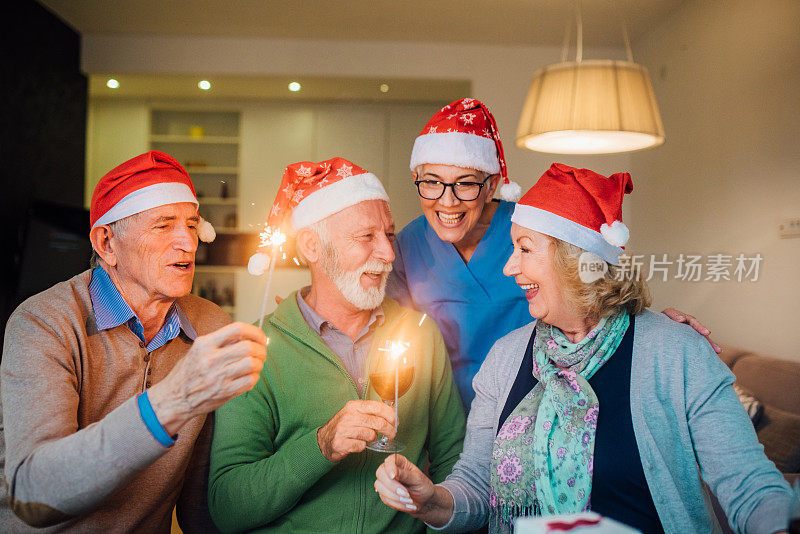 快乐的人们拿着闪闪发光的东西，戴着圣诞老人的帽子