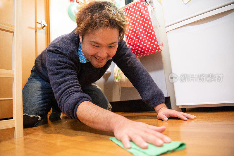 一名日本男子正在清理厨房地板