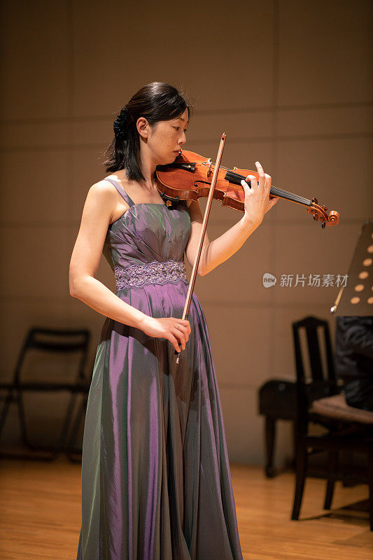一个女人在音乐厅拉小提琴