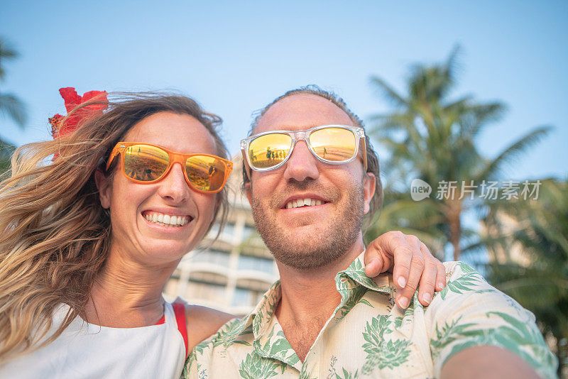 年轻夫妇在美丽的海滩上自拍照片-凉爽的度假概念-威基基，夏威夷，美国