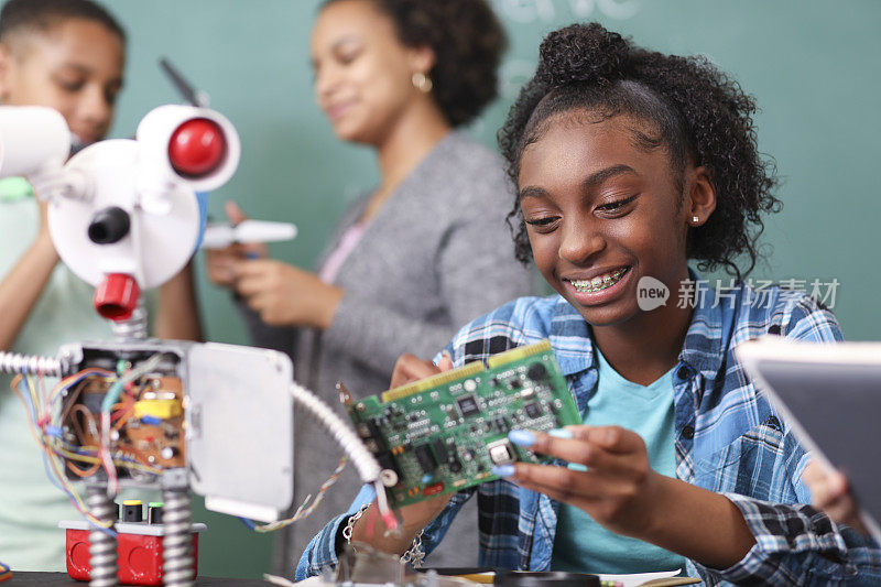 初中年龄段的学生在技术、工程课上制造机器人。