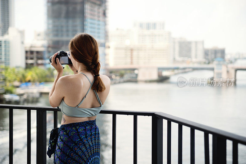 一名年轻女子度假时在阳台上录影。