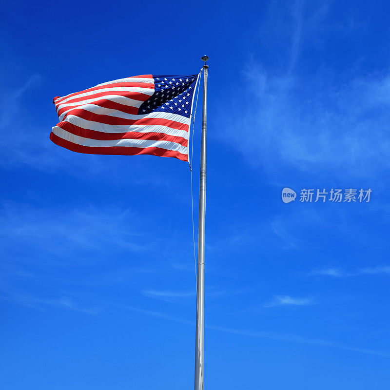 湛蓝的天空下，高高的旗杆上悬挂着美国国旗