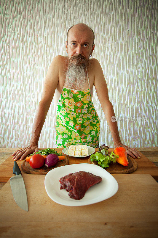 一个留着胡子，穿着围裙的有趣的家伙，展示肉和蔬菜沙拉的配料