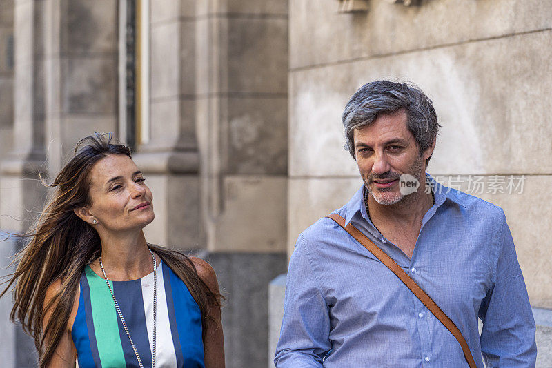 一对美丽的年轻夫妇在阿根廷布宜诺斯艾利斯的大街上边走边聊。