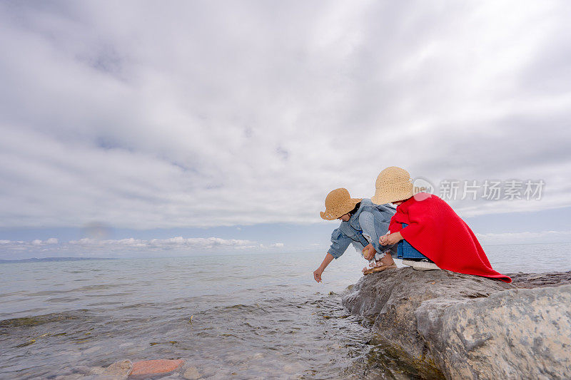 两姐妹在湖边喂鱼