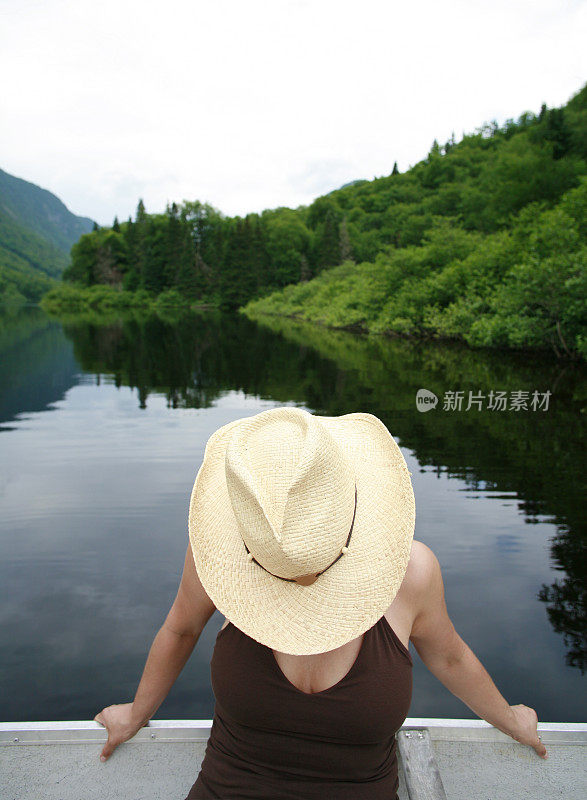 划艇上戴草帽的女人。