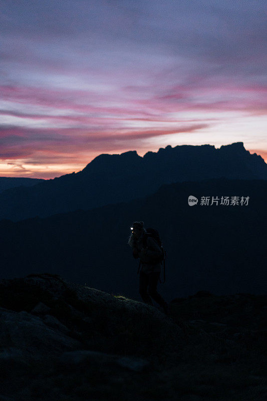 日出时，女徒步旅行者穿过山脊