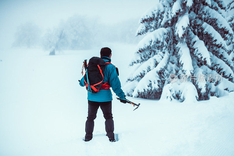 男登山运动员跑进暴风雪中