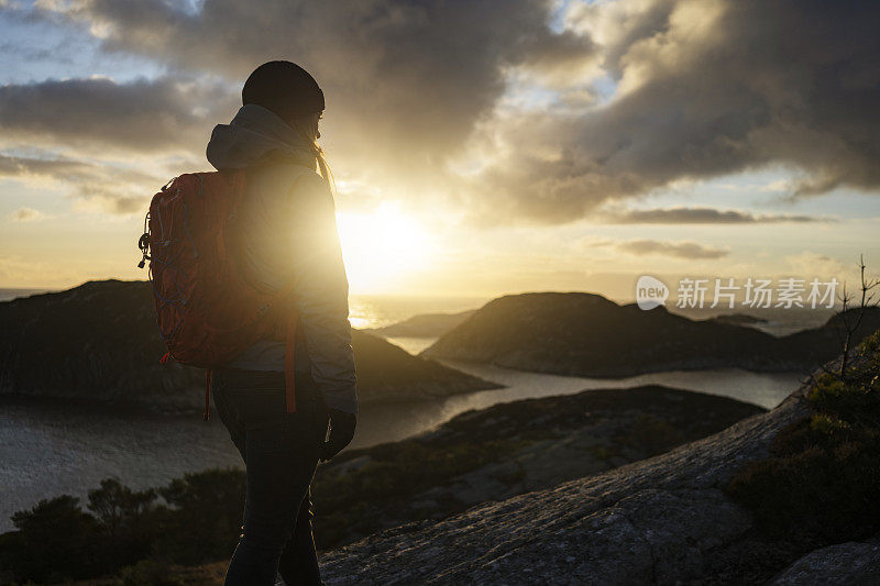 女性户外探险:在挪威徒步旅行，在峡湾边的山上