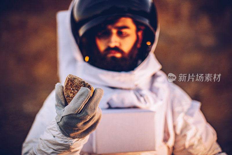 宇航员在火星上拿着一块石头