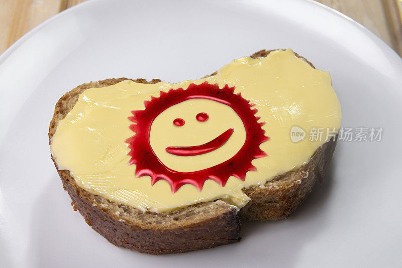 涂了黄油的面包上的果酱形成的太阳形状。