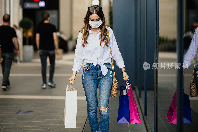 女人戴着保护面罩和购物