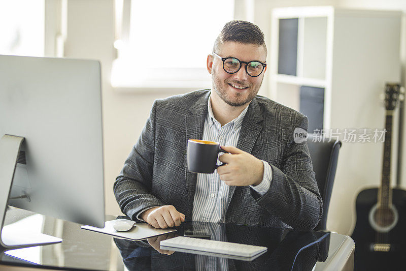 成功企业家在舒适的家庭办公室喝咖啡的肖像