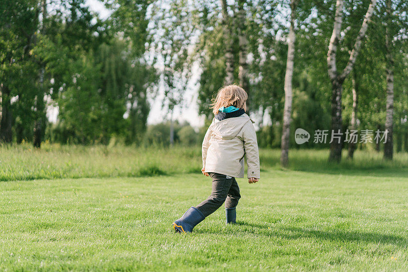 小男孩在公园的草地上奔跑