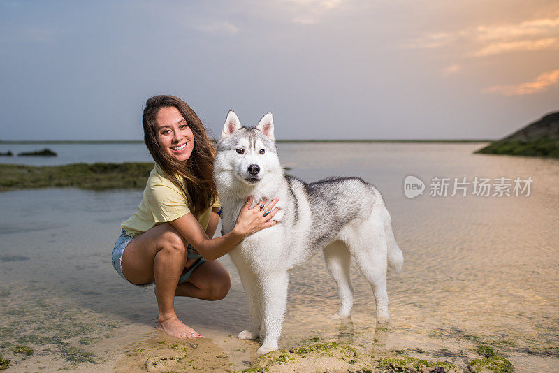 混血女人和她的狗在海滩上