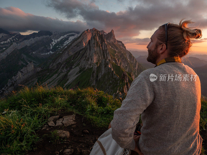 一名男子在瑞士徒步旅行，然后停下来看风景