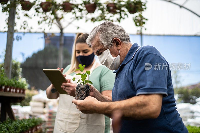 售货员在花园中心帮助客户购买植物