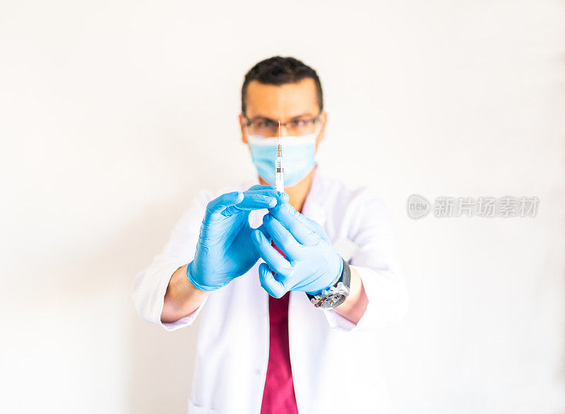 医生手拿医用针剂，在白色的背景下注射疫苗。库存图片