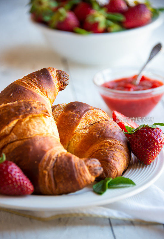 牛角面包配草莓酱和新鲜水果，美味健康的早餐