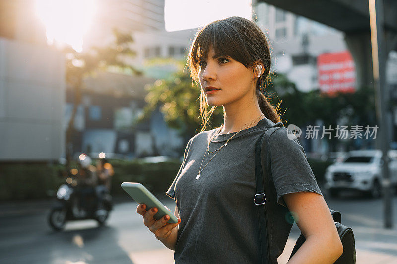 年轻女子拿着手机在街上看