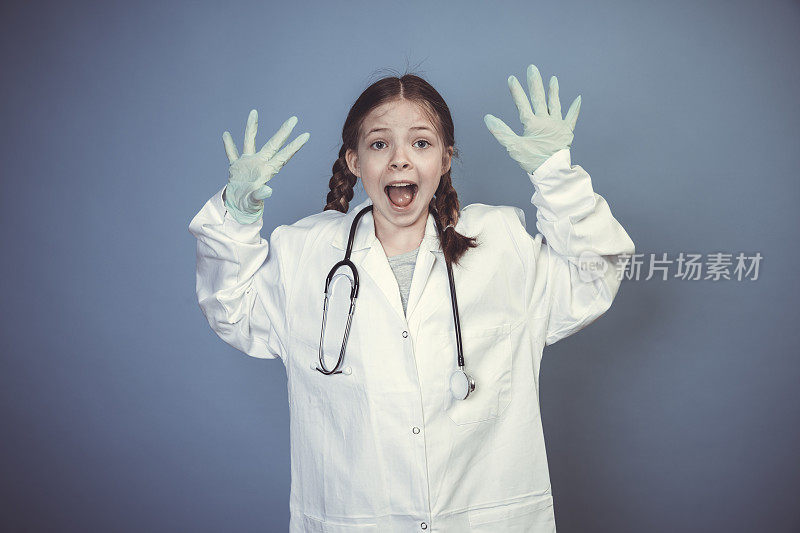 漂亮的年轻女孩打扮成医生，戴着绿色的橡胶手套和听诊器