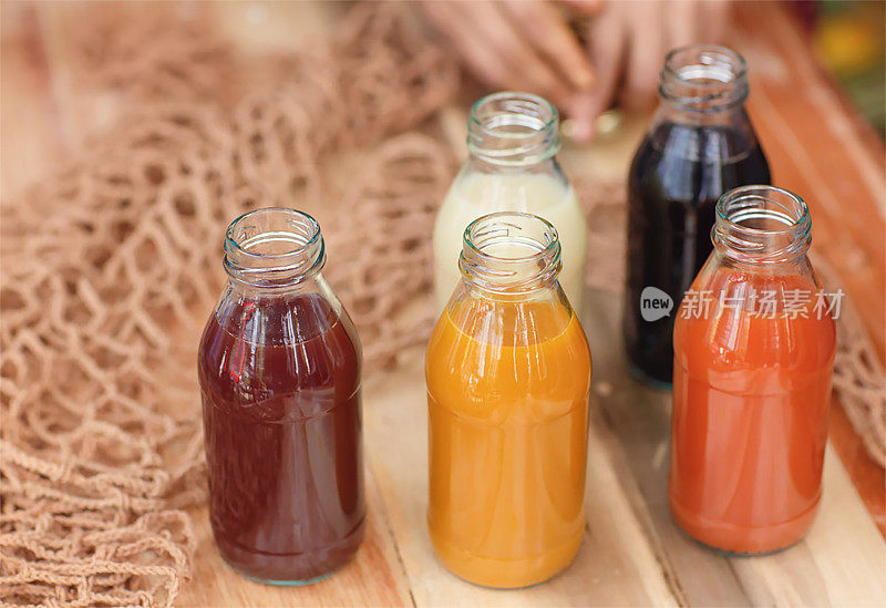 许多不同的Jamu饮料-印度尼西亚草本饮料在玻璃瓶与天然成分:姜黄，生姜，酸橙，棕榈糖，柠檬草，罗角果在木桌上。健康的生活方式