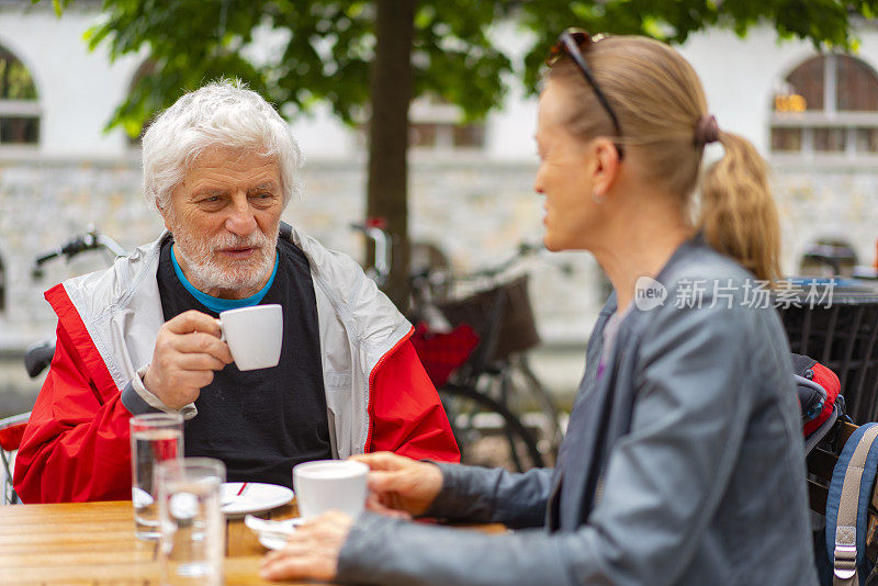 帕金森病患者与妻子在餐厅喝咖啡的肖像。