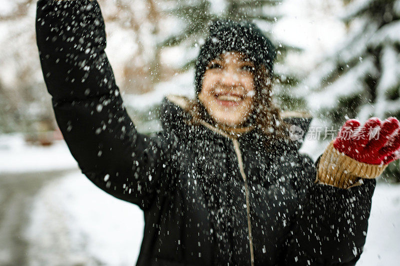 快乐的年轻女子在玩雪