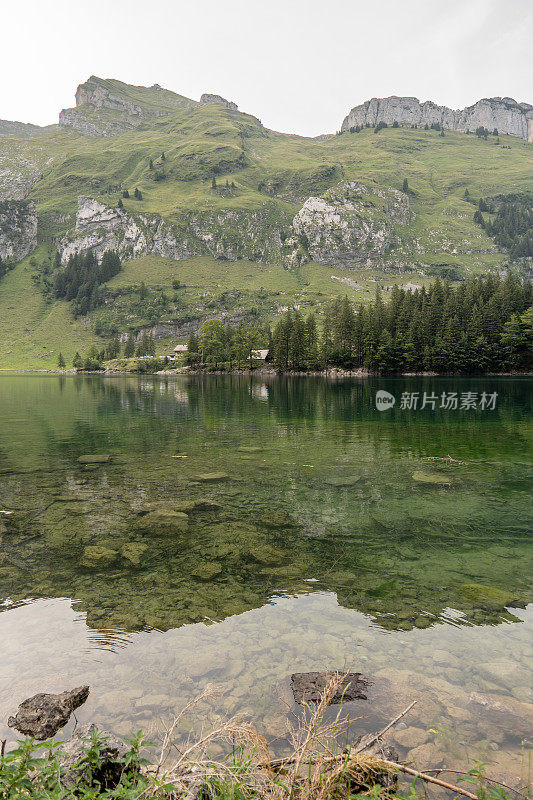 日落时美丽的高山湖泊，阳光照在山脊上，反射在水面上