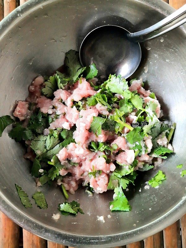 将香菜丝与猪肉末混合在碗中-食物的准备。