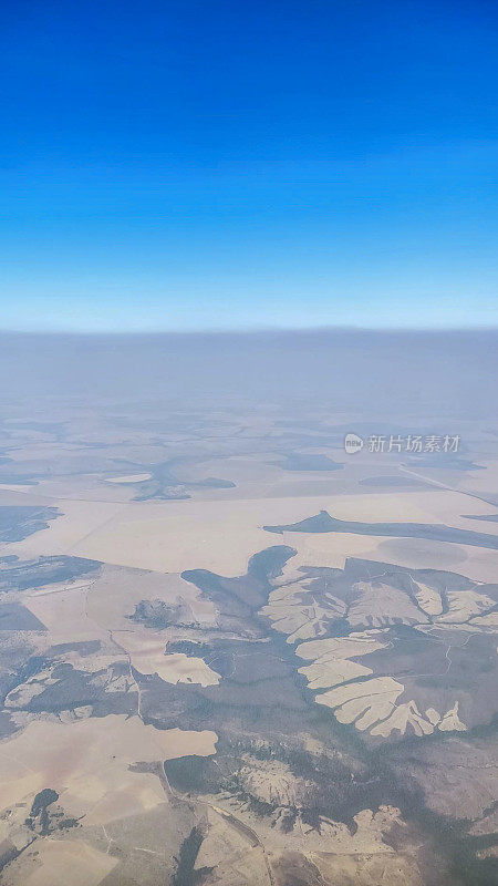 从飞机内看到的农田和云层景观