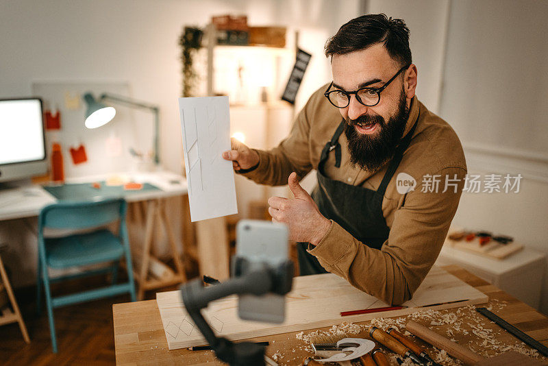 手工艺人展示印刷纸，而在工作室视频博客