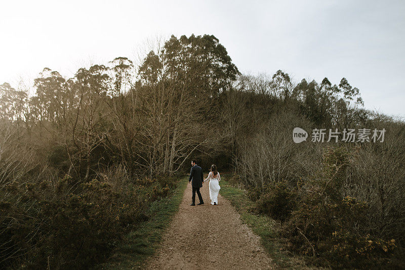 一对新婚夫妇散步的后视图