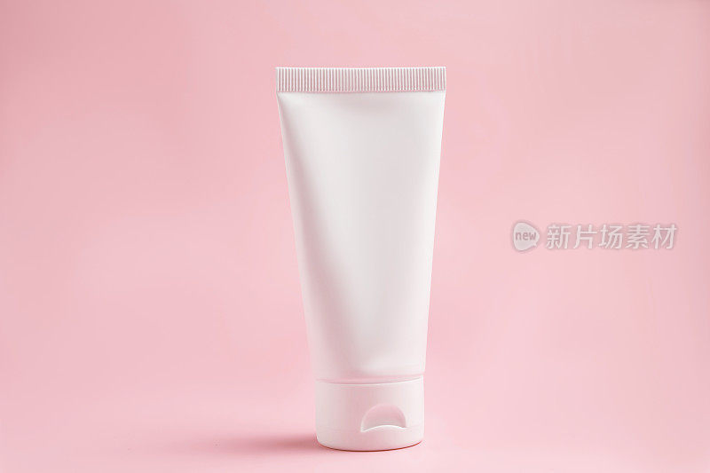 白色挤压瓶塑料管的模型，用于医药或化妆品品牌-奶油，凝胶，皮肤护理，牙膏。化妆品瓶容器在粉红色的背景。极简主义