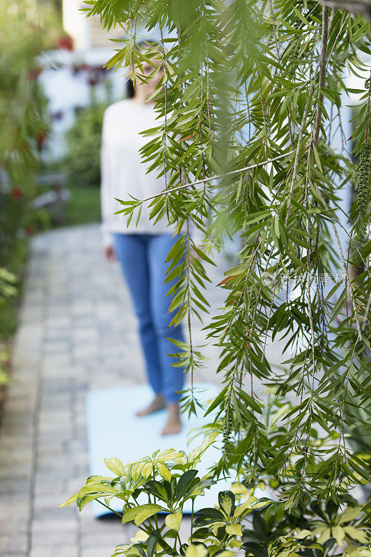 后院露台上郁郁葱葱的树叶，女人失去焦点