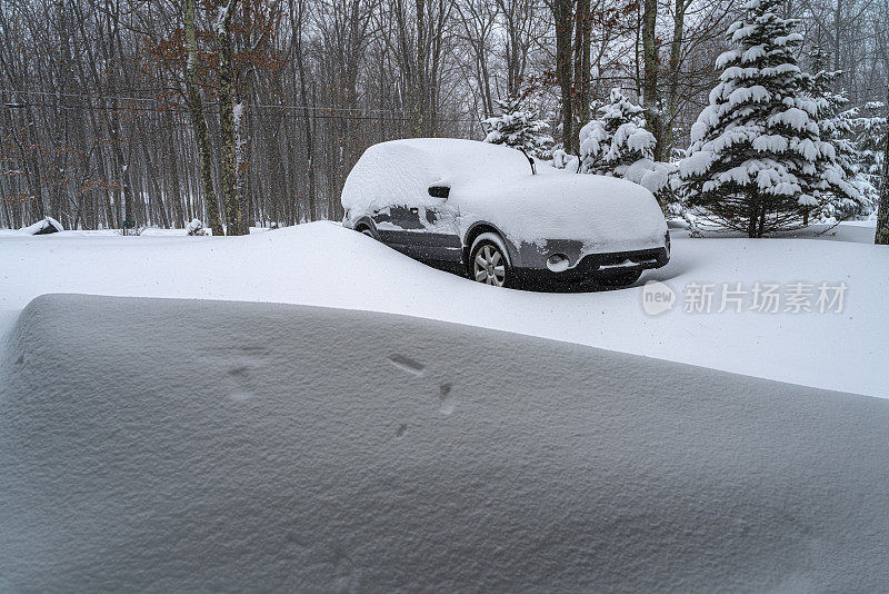在一场冬季暴风雪中，汽车被大雪覆盖。