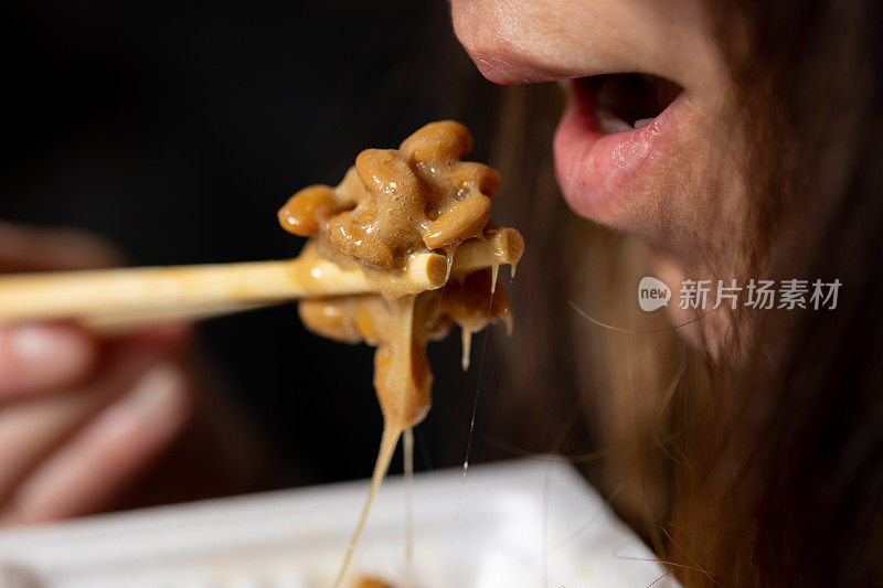 一个女人吃日本超级食物纳豆(发酵大豆)的特写