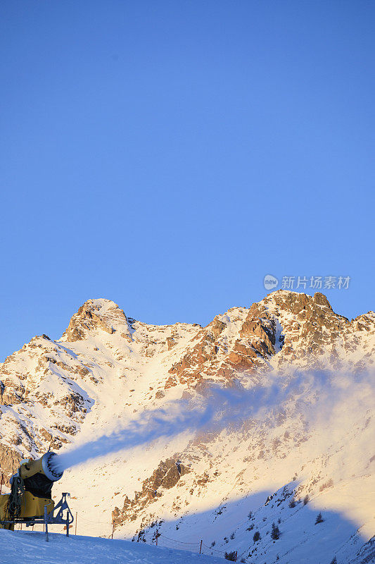 用造雪枪造雪。滑雪坡人工下雪。滑雪场配雪炮造雪机。美丽的冬季自然。山顶上的新雪。高山景观滑雪场。