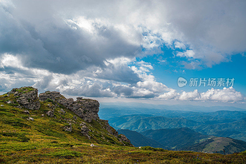 在一个阳光明媚的夏日里，有美丽的山峦和岩石景观。