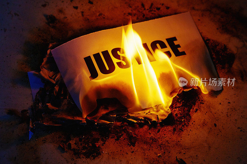 正义被摧毁:词语在火焰中燃烧，代表着不公正