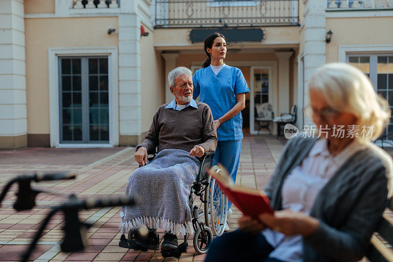 护工带老人去养老院。