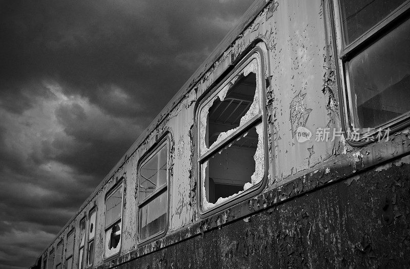 在一个迷失的地方。一辆窗户被砸碎的旧客车，黑色的乌云在世界尽头的一个车站堆积起来。