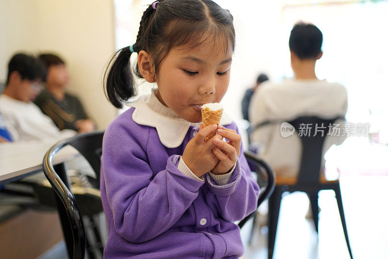 亚洲女孩在饮料店吃冰淇淋