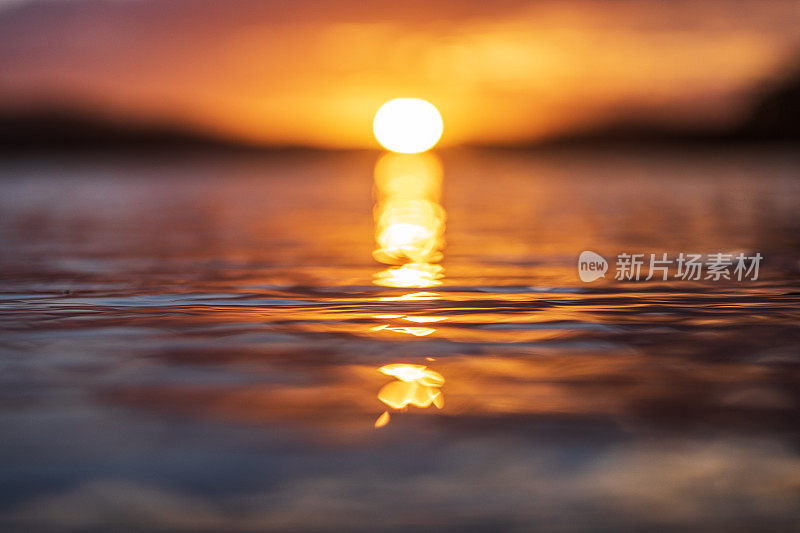 太阳落山时反射在光滑海面上的光线近照