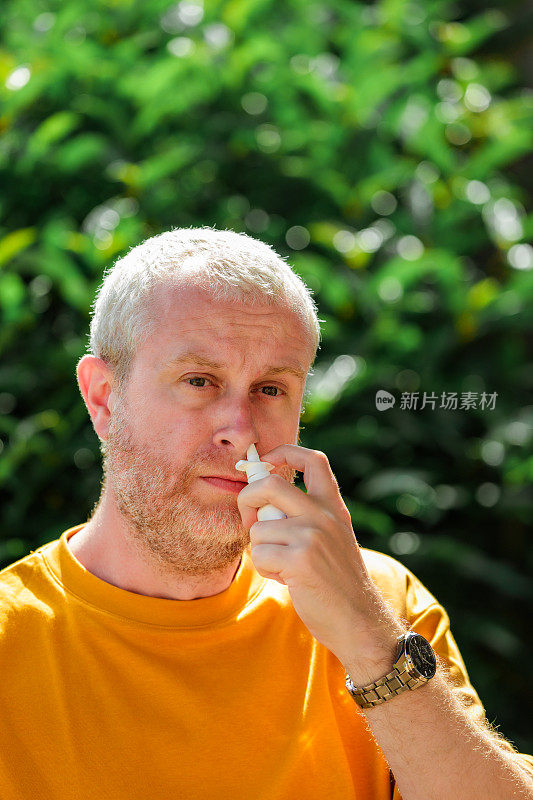 患有花粉热过敏的男子正在使用鼻腔喷雾剂