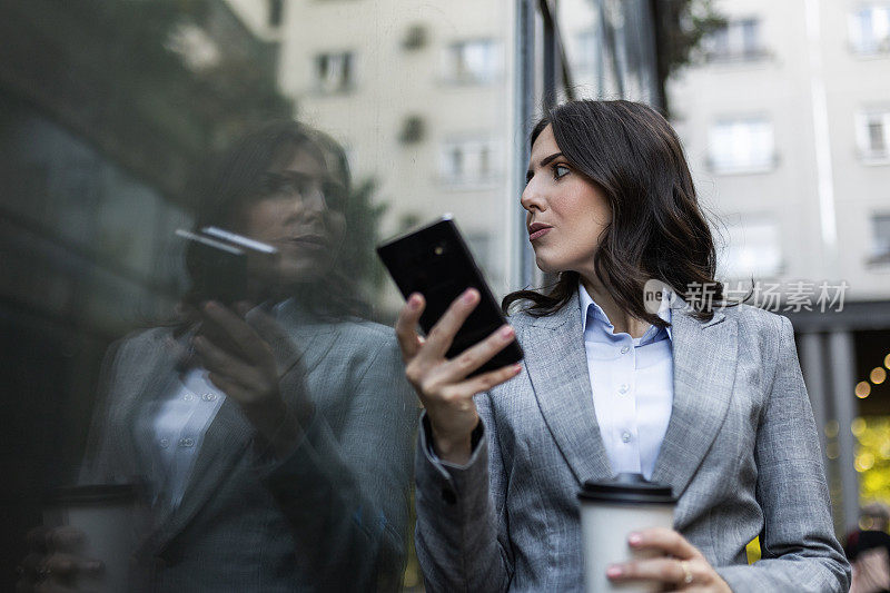 兼顾咖啡和电话的女商人