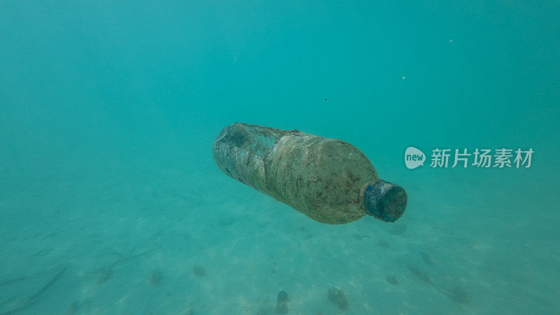 生锈的旧塑料瓶漂浮在海洋里